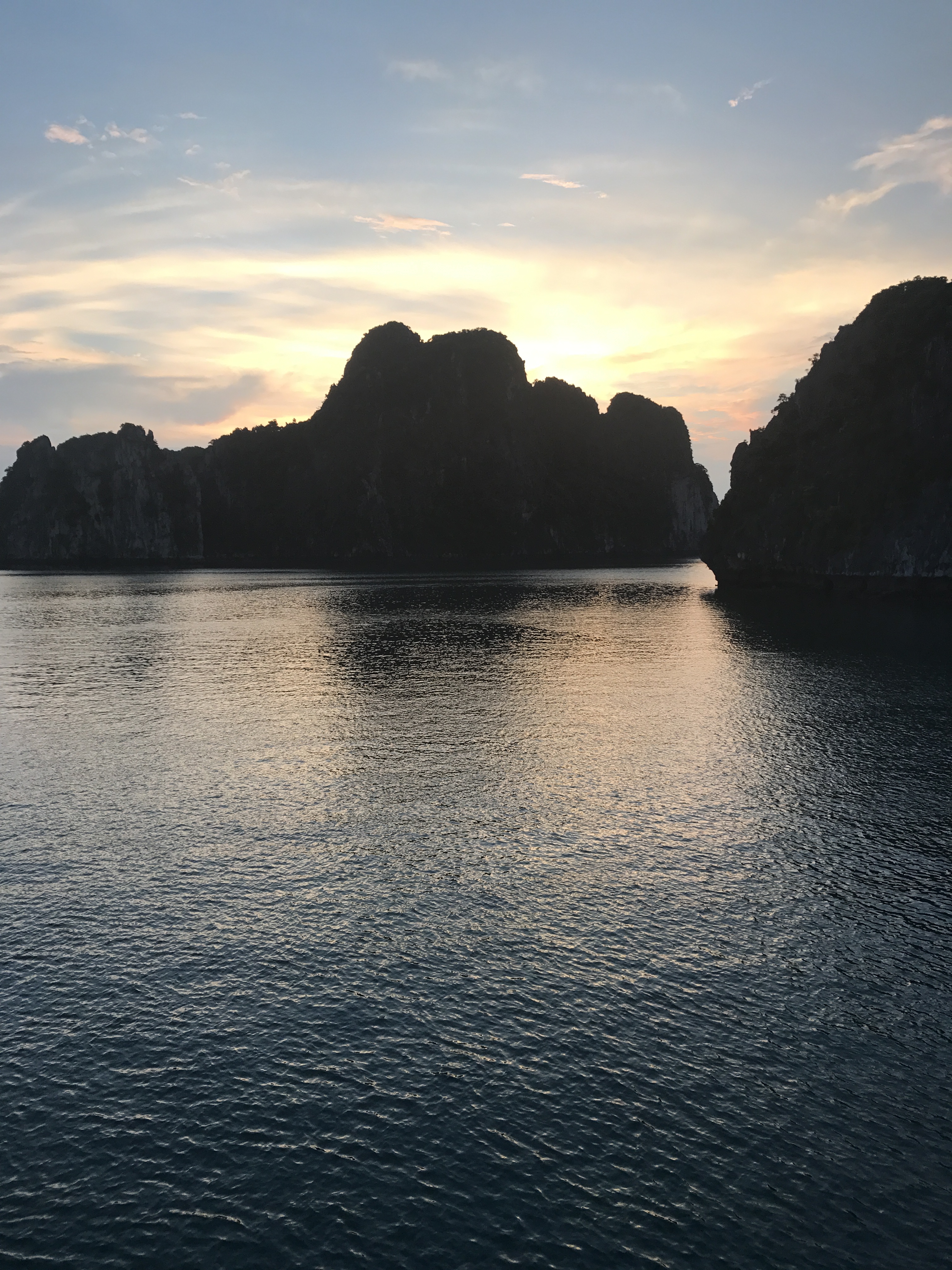 Scenic view of a bay with limestone karsts at sunset.