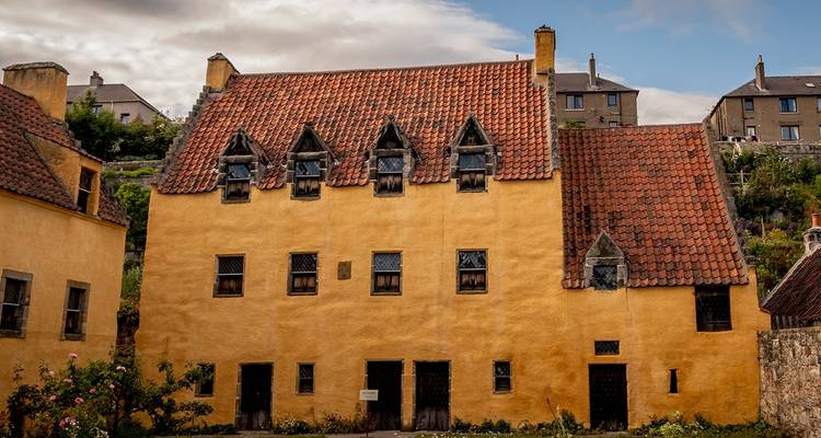Maison traditionnelle jaune avec un toit rouge.