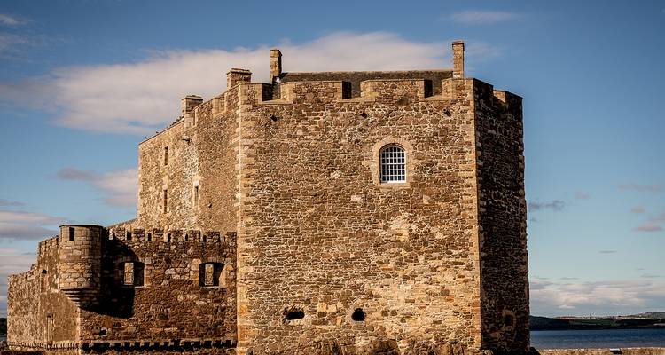 Bâtiment historique en pierre au bord de l'eau.