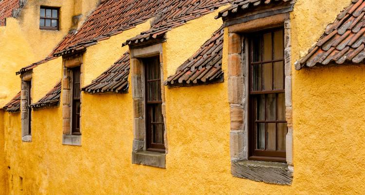Bâtiment traditionnel jaune avec un toit de tuiles rouges.