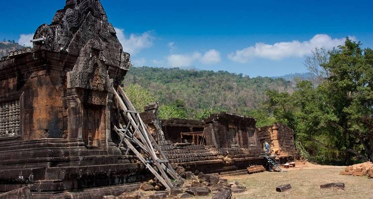 Oude tempelruïnes met bergen op de achtergrond.