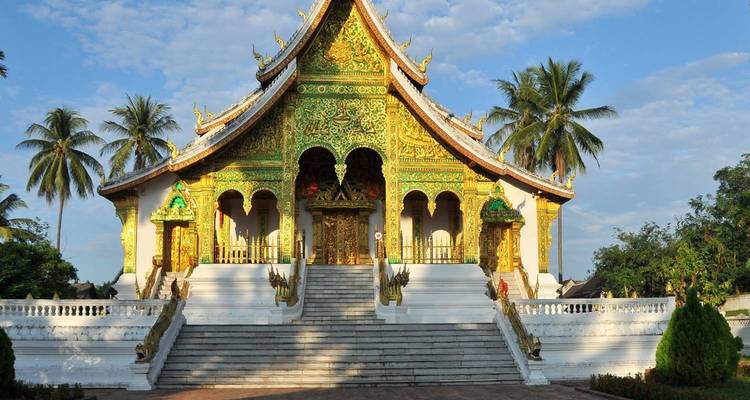 Gouden en groene tempel met decoratieve details en palmbomen.