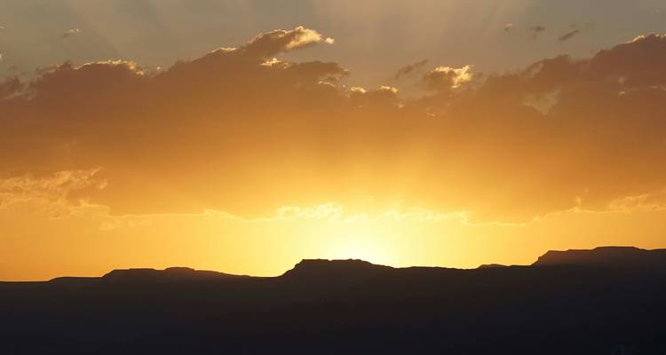 Coucher de soleil sur les montagnes avec un ciel doré.