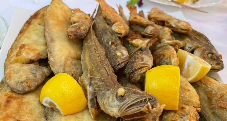 Poisson frit servi avec des tranches de citron dans une assiette.