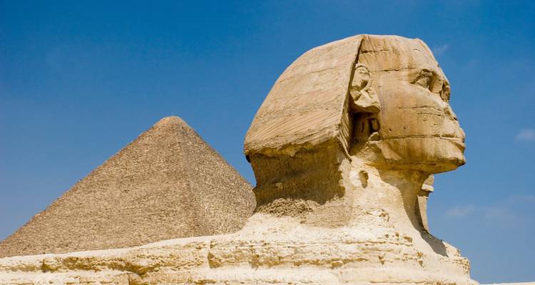 The Sphinx and pyramids against a clear blue sky.