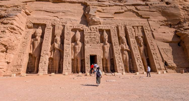 Visitors approach the rock-cut façade of Abu Simbel’s smaller temple carved with colossal statues