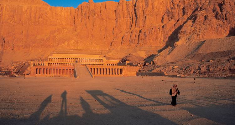 Imposing ancient temple structure with shadows cast on the desert floor.