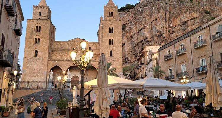 Evening diners gather in the piazza before Cefalù Cathedral carved into a rocky cliff.