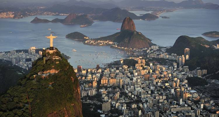 Panorama aéreo de Río de Janeiro con la estatua del Cristo Redentor mirando la ciudad y el Pan de Azúcar.
