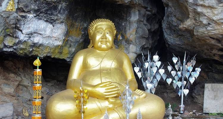Estatua dorada de Buda en una cueva.