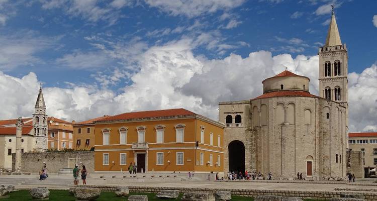 Historische kerk en klokkentoren tegen een bewolkte blauwe hemel in Zadar.
