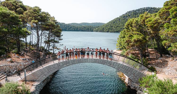 Un grupo de personas paradas en un puente sobre el agua.