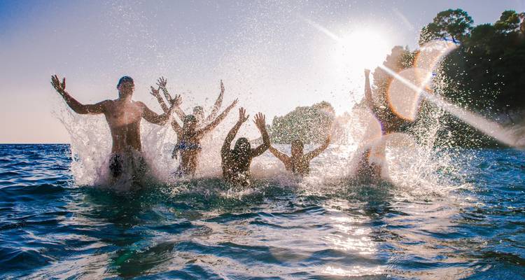 People enjoying in the water with splashes and sunlight.