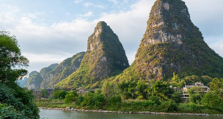 Karst mountains with lush vegetation along a river.