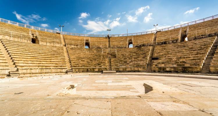 Amphithéâtre romain antique avec des sièges en pierre en gradins sous un ciel bleu éclatant