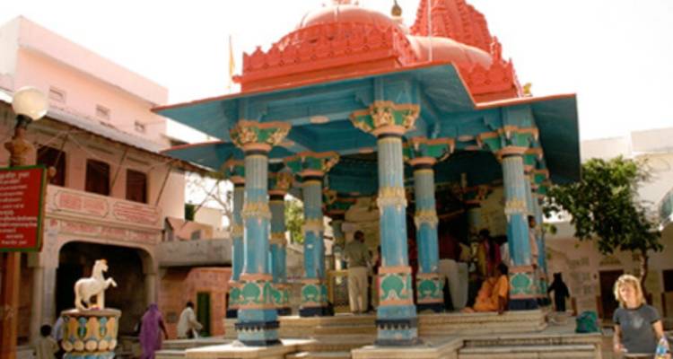 A colorful temple with people around it.