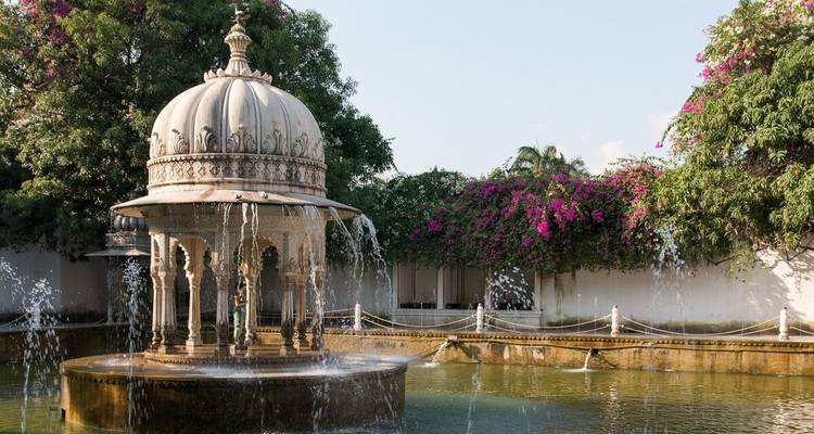 A picturesque garden with a domed fountain adorned with flowers.