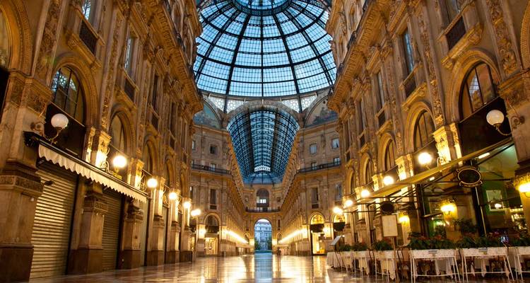 Galerie Vittorio Emanuele II élégamment éclairée avec sa coupole en verre imposante et ses façades ornées.