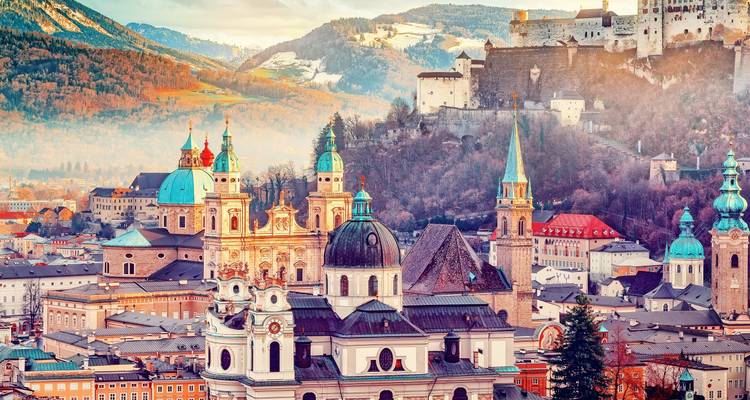 Toits et dômes aux couleurs riches de la vieille ville de Salzbourg sous la forteresse de Hohensalzburg et les sommets alpins.