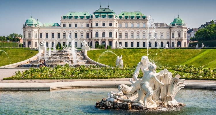El Palacio Belvedere y sus fuentes ornamentadas bañados en brillante luz del día.