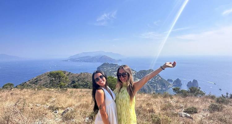 Dos mujeres posando con una vista clara del mar.
