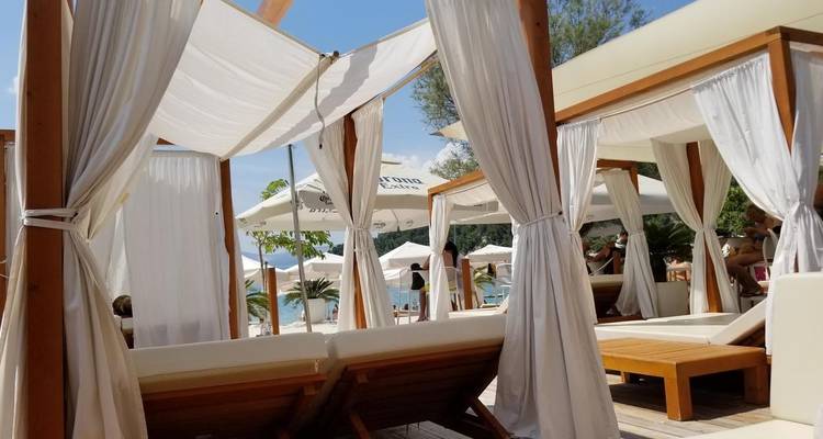 Espace de détente extérieur avec cabanas par une journée ensoleillée.