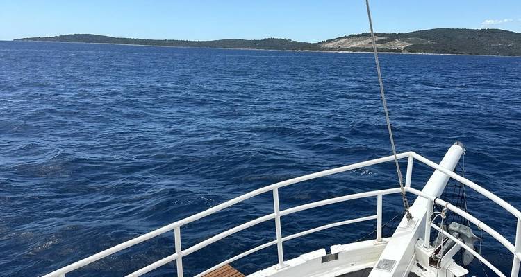 Proue d'un bateau naviguant sur un vaste océan bleu.