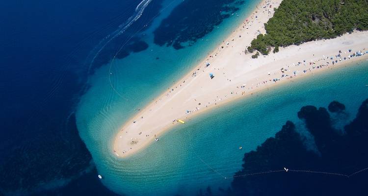 Aerial view of a beach with a unique pointed shape extending into the sea.