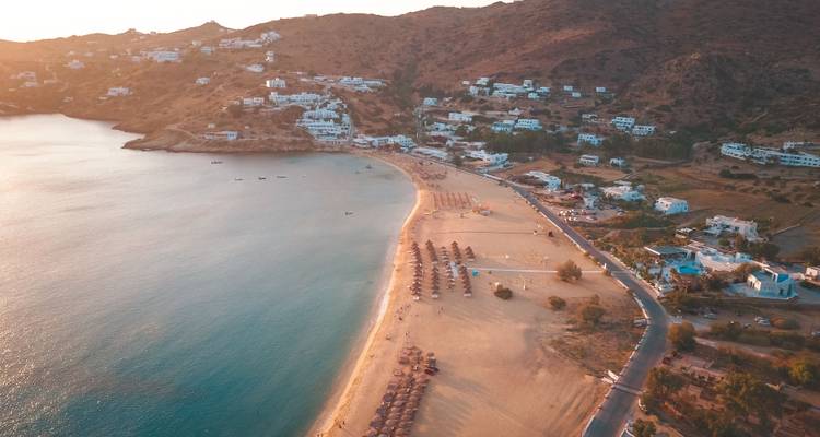 Vue aérienne d'une plage avec du sable doré et des eaux claires à Ios, en Grèce.