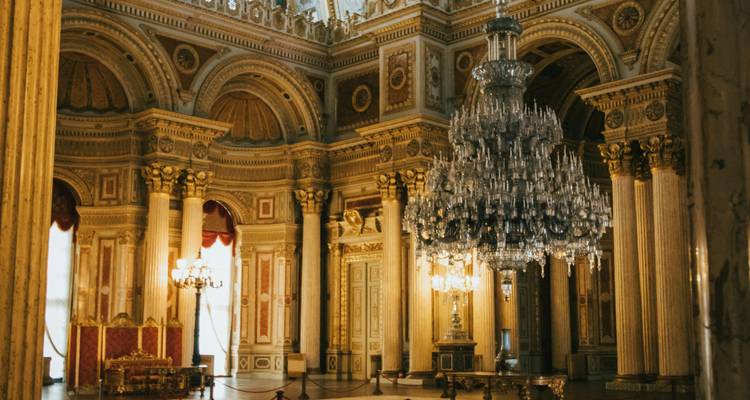 Lavishly decorated interior of a historic building with chandeliers.