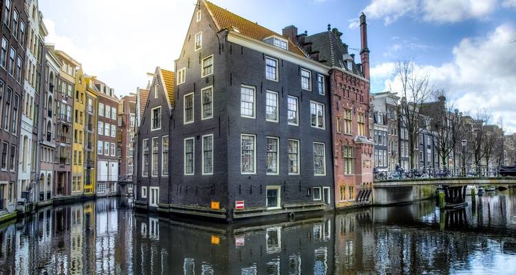 Colorful buildings along a canal under a bright blue sky