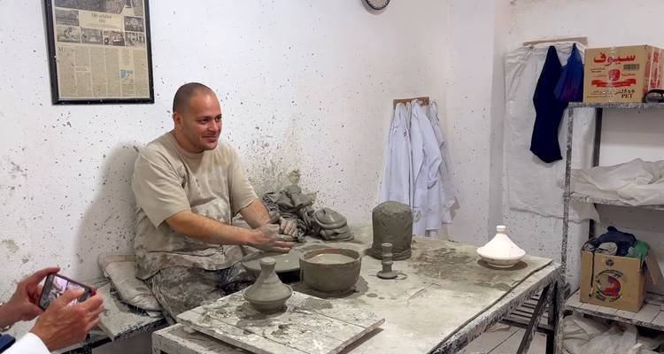 Ambachtsman die klei vormt op een pottenbakkersschijf in een werkplaats