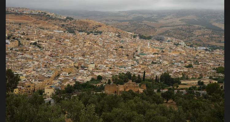 Bewolkt panoramisch uitzicht op Fes medina uitgestrekt over glooiende heuvels
