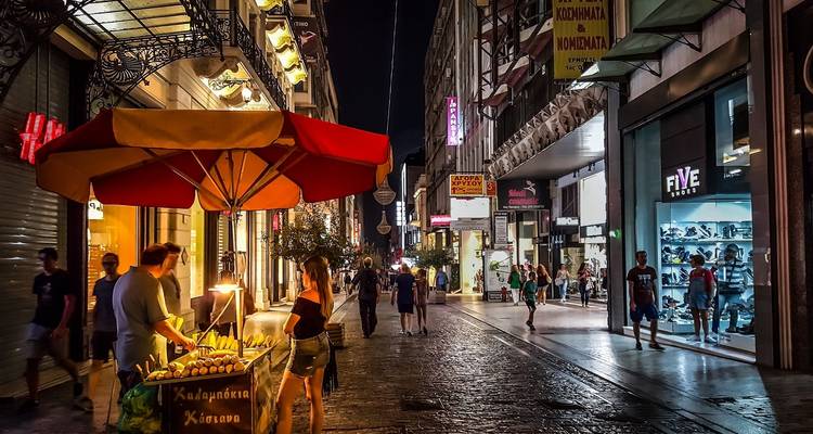 Nachtmarkt-Szene mit Menschen, die an Straßenimbissständen stöbern.