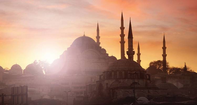 Les mosquées d'Istanbul en silhouette et les minarets élancés baignés dans une brume de lever de soleil brillant.