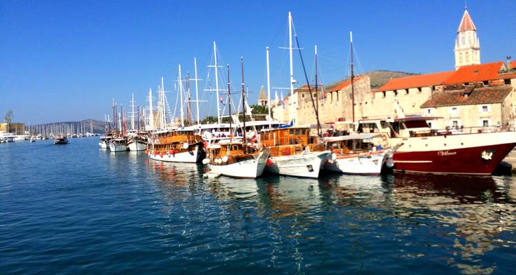 Vista del puerto con barcos y una torre de iglesia.