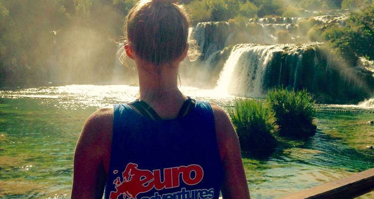 Persona frente a una cascada llevando una camisa de marca.