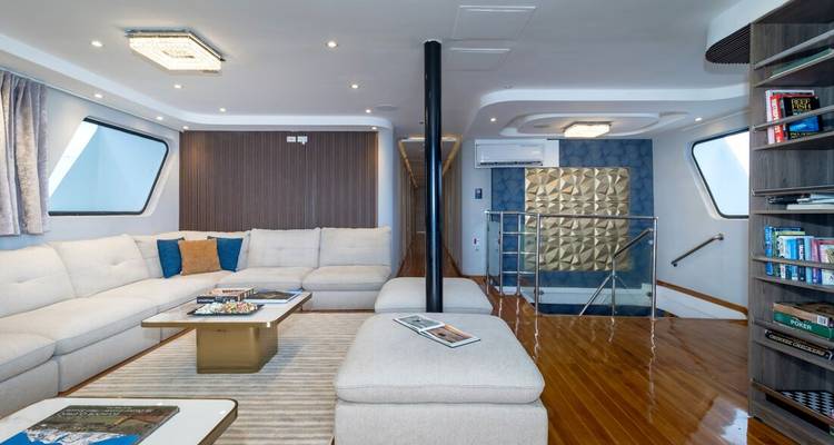 Ruime en elegante woonruimte met zitplaatsen en boekenplanken op een schip.