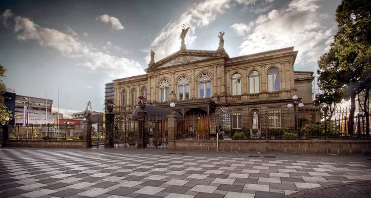 Grand Théâtre National dans une vaste place pavée de galets éclairée par une douce lumière naturelle