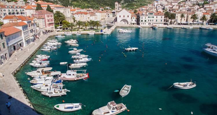Ville côtière avec des bateaux amarrés dans l'eau cristalline.
