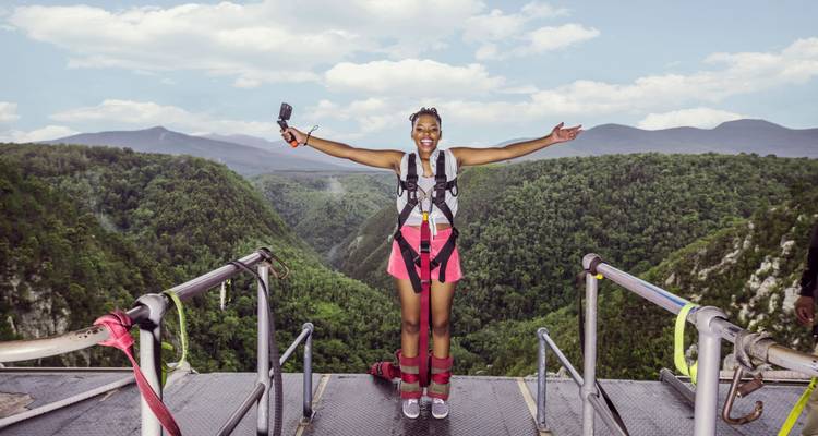Persona lista para saltar en bungee con fondo de valle escénico.