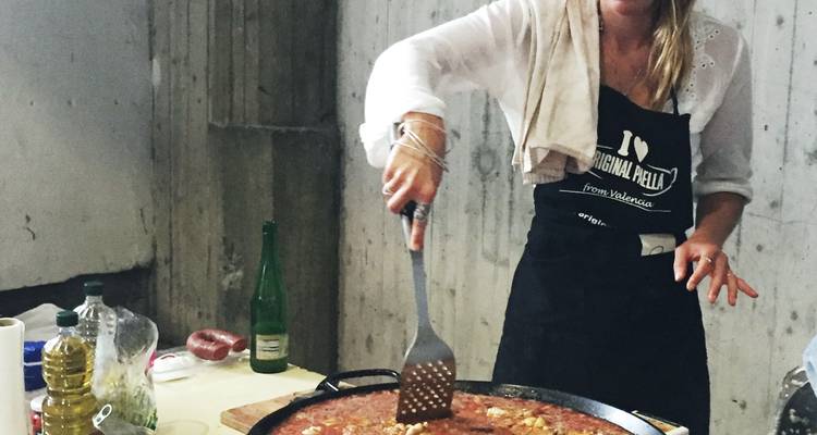 Person, die in einer Küche mit einer großen Pfanne kocht.