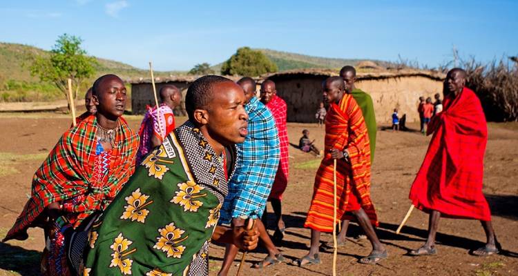 Group of Maasai men engaging in a traditional dance in colorful attire.
