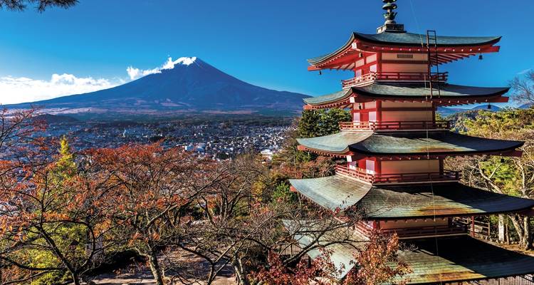 Heuveltop pagode met uitzicht op stad met Mount Fuji sneeuwpiek onder heldere blauwe hemel.