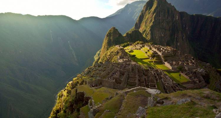 Machu Picchu ruïnes met op de achtergrond de zonovergoten bergen.
