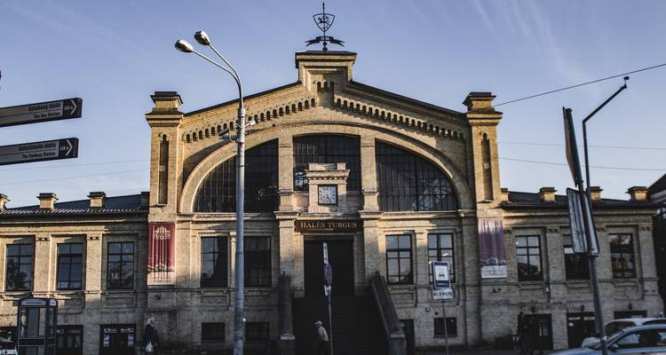 Edificio histórico con arcos y reloj en Riga.
