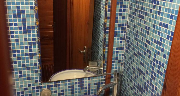 View of a small bathroom with mosaic tiles.