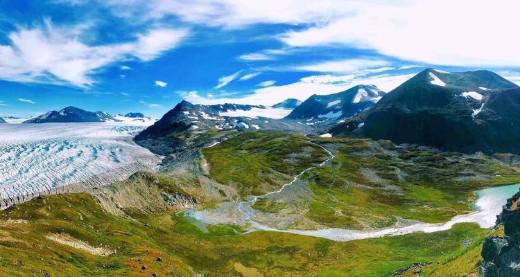 Uitgestrekt uitzicht op gletsjer en bergen met levendige lucht.