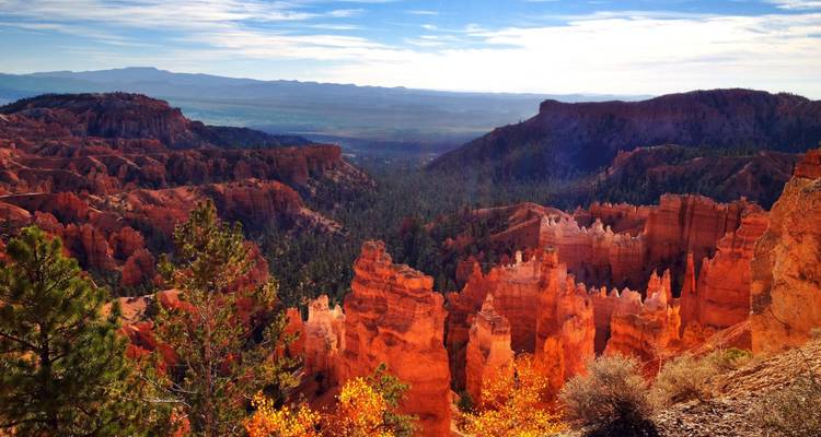 Colorful rock formations and valleys under a blue sky in Bryce Canyon National Park.