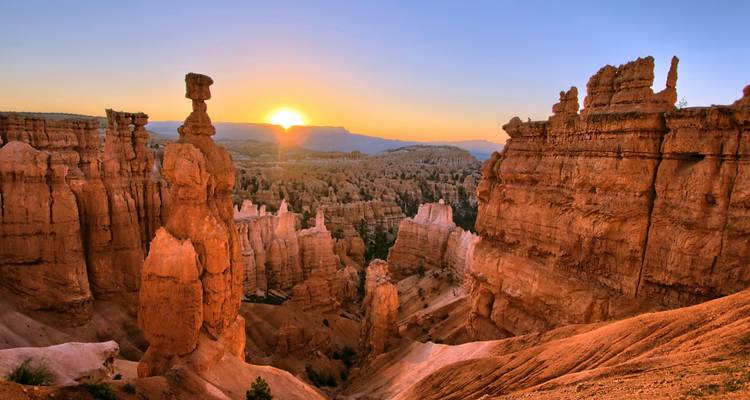 Sunrise over Bryce Canyon with iconic hoodoos and clear skies.